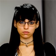 Serious-looking young woman with dark hair and glasses